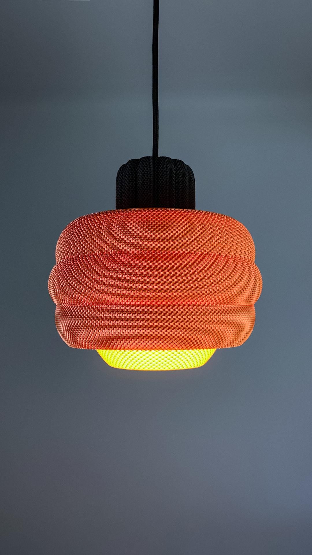 Orange textured pendant light against a gray background