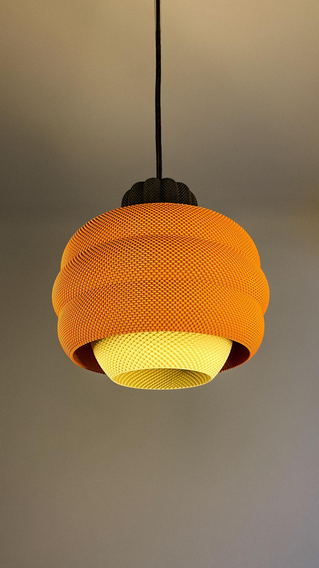 Orange knitted lampshade on a plain background