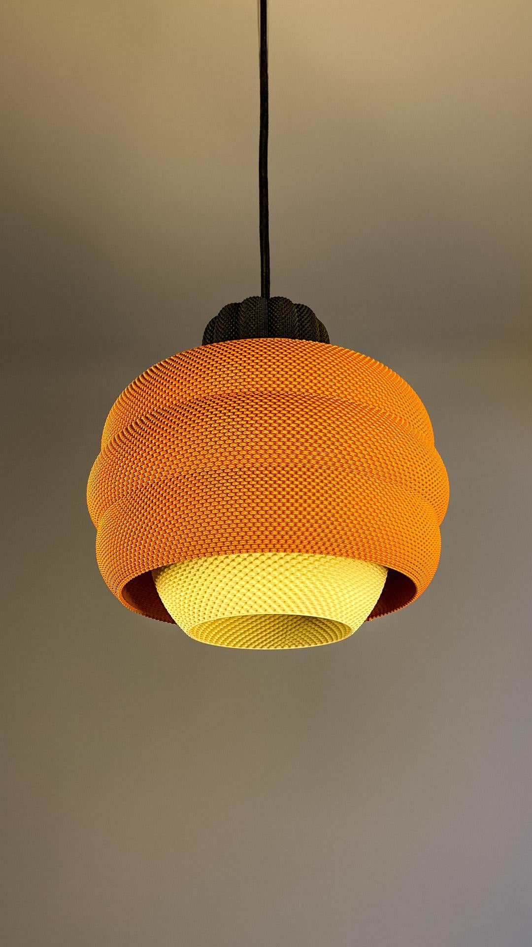 Orange knitted lampshade on a plain background