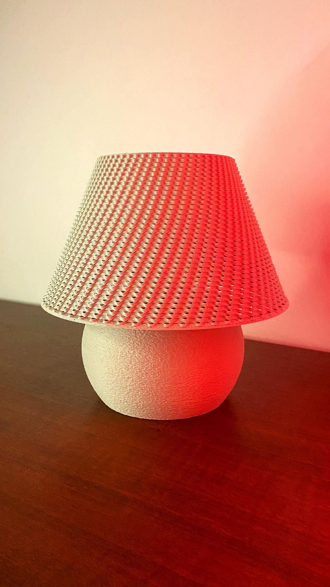 Lamp with a red textured shade on a wooden surface