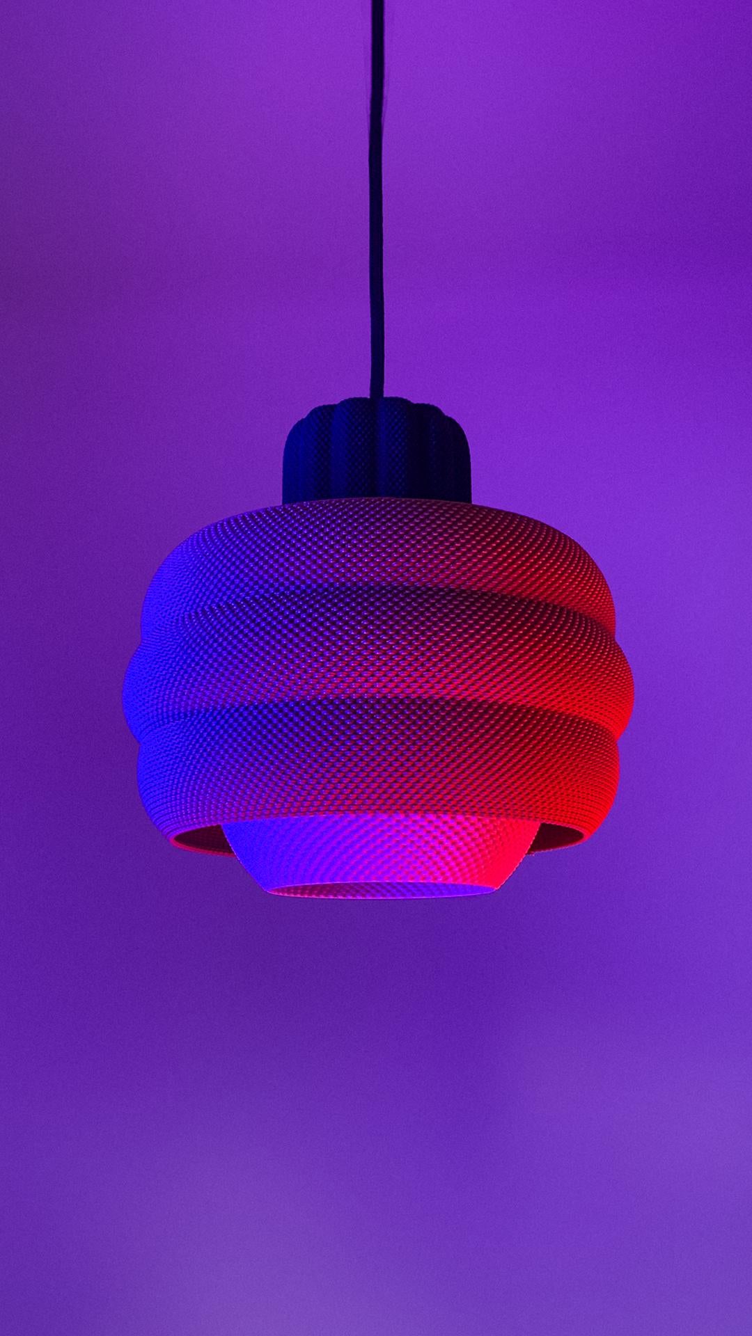Modern pendant light with a mesh design on a purple background