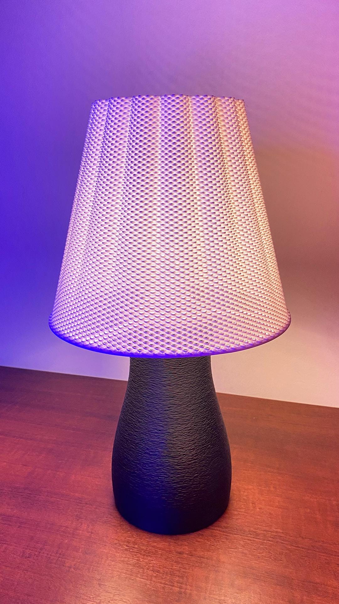 Table lamp with textured white shade on a wooden surface