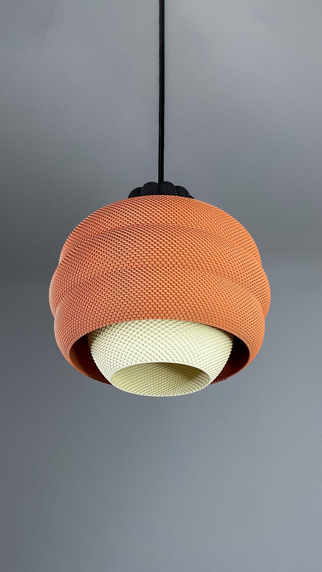 Orange textured pendant light against a gray background