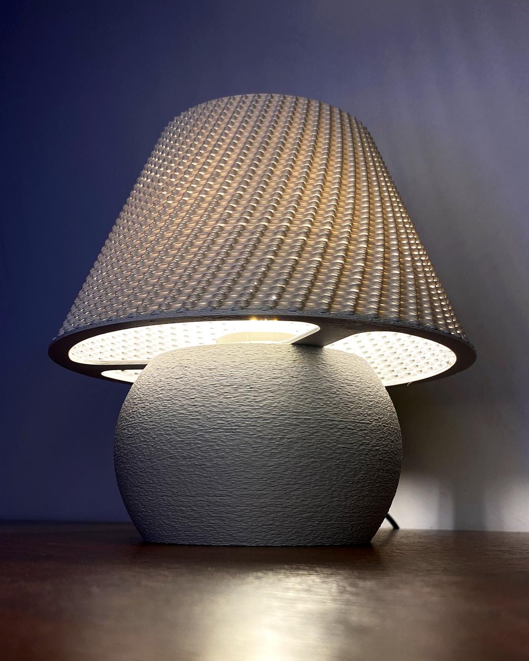 Table lamp with textured shade and base on a dark background