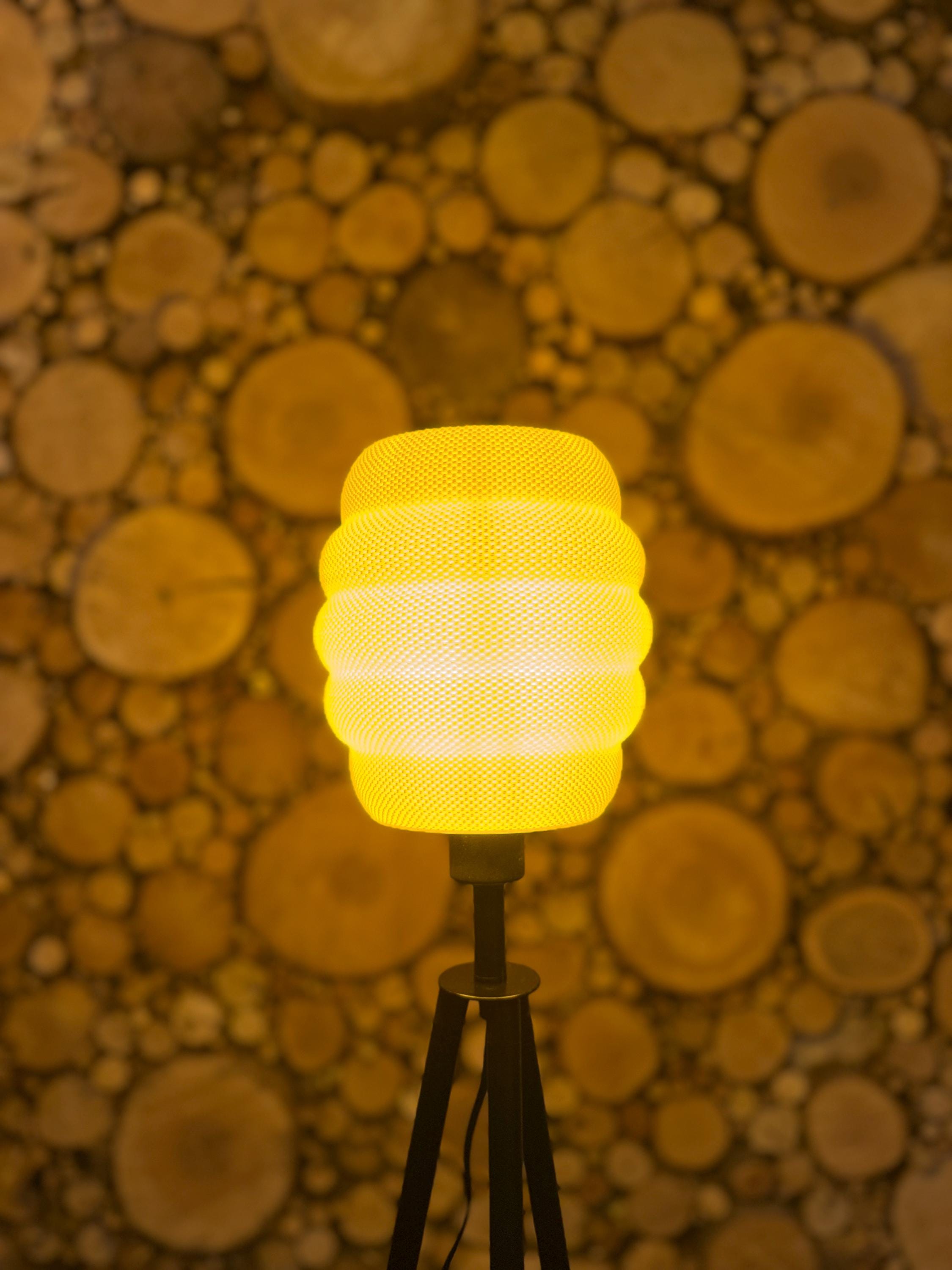Yellow textured light bulb on a stand against a wooden background