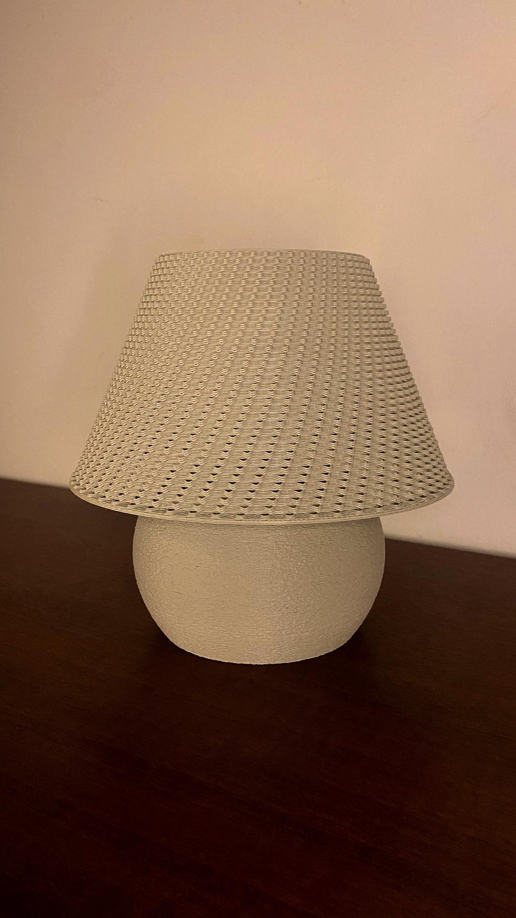 Table lamp with woven shade on a dark surface