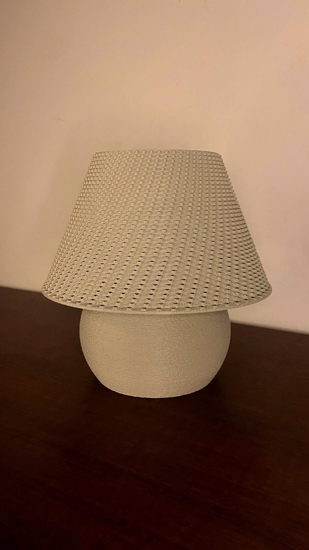 Table lamp with woven shade on a dark surface