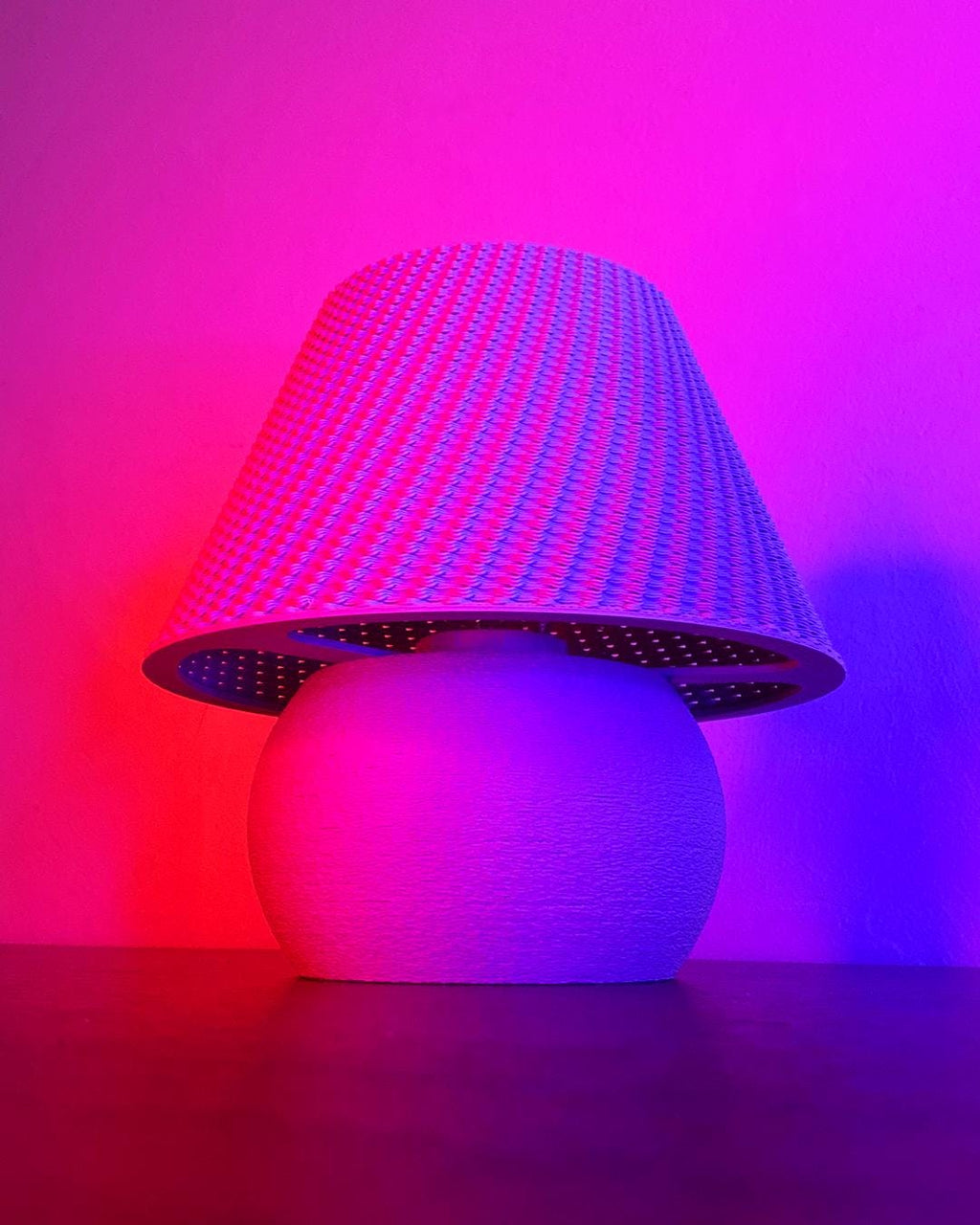 Decorative lamp with a textured base and colorful LED shade against a pink and purple gradient background.